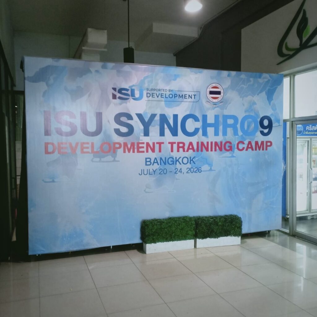 ป้ายไวนิล Backdrop ขนาดใหญ่ สำหรับงาน ISU Synchro9 Development Training Camp Bangkok 2026 ใช้เป็นฉากหลังถ่ายภาพและประชาสัมพันธ์ภายในงานกีฬา