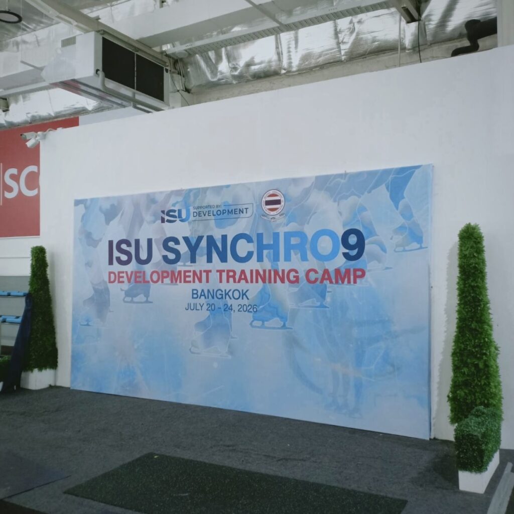 ป้ายไวนิล Backdrop ขนาดใหญ่ สำหรับงาน ISU Synchro9 Development Training Camp Bangkok 2026 ใช้เป็นฉากหลังถ่ายภาพและประชาสัมพันธ์ภายในงานกีฬา