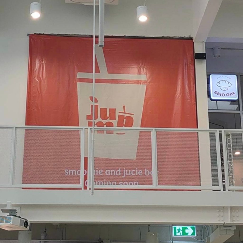 ป้ายไวนิลโฆษณาร้าน Jump บริเวณพื้นที่ชั้นบนของศูนย์การค้า มองเห็นได้จากหลายมุมและช่วยสื่อสารแบรนด์